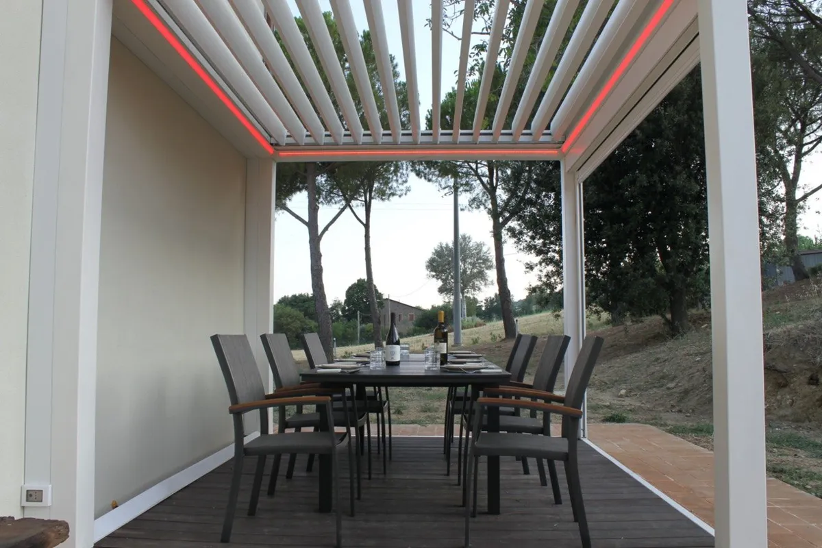 La veranda apparecchiata per la cena, con le luci accese al calar del sole