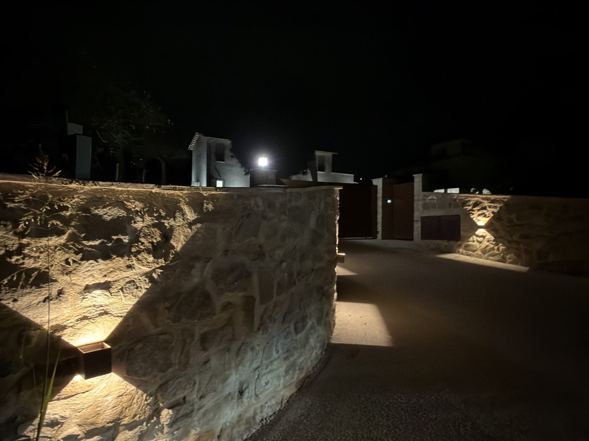 L'ingresso privato illuminato di The Lodge Umbria, di sera, con cancello automatizzato