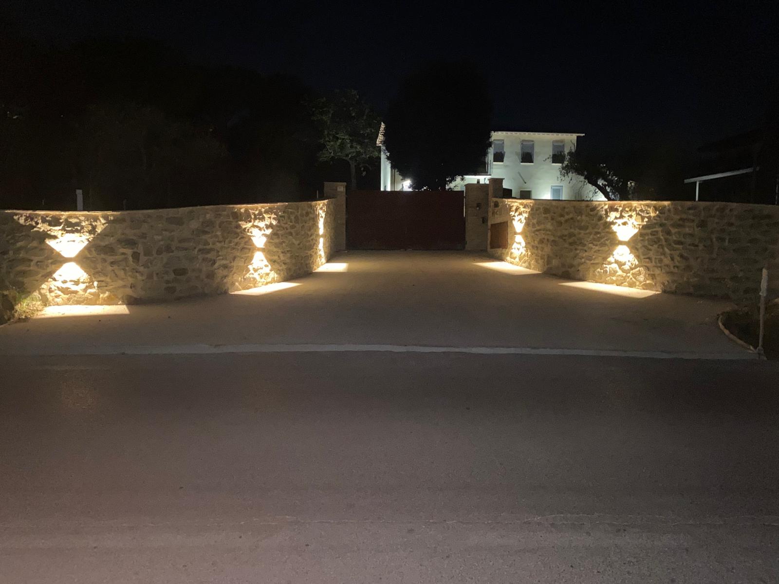 L'ingresso privato illuminato di The Lodge Perugia, di sera, con cancello automatizzato