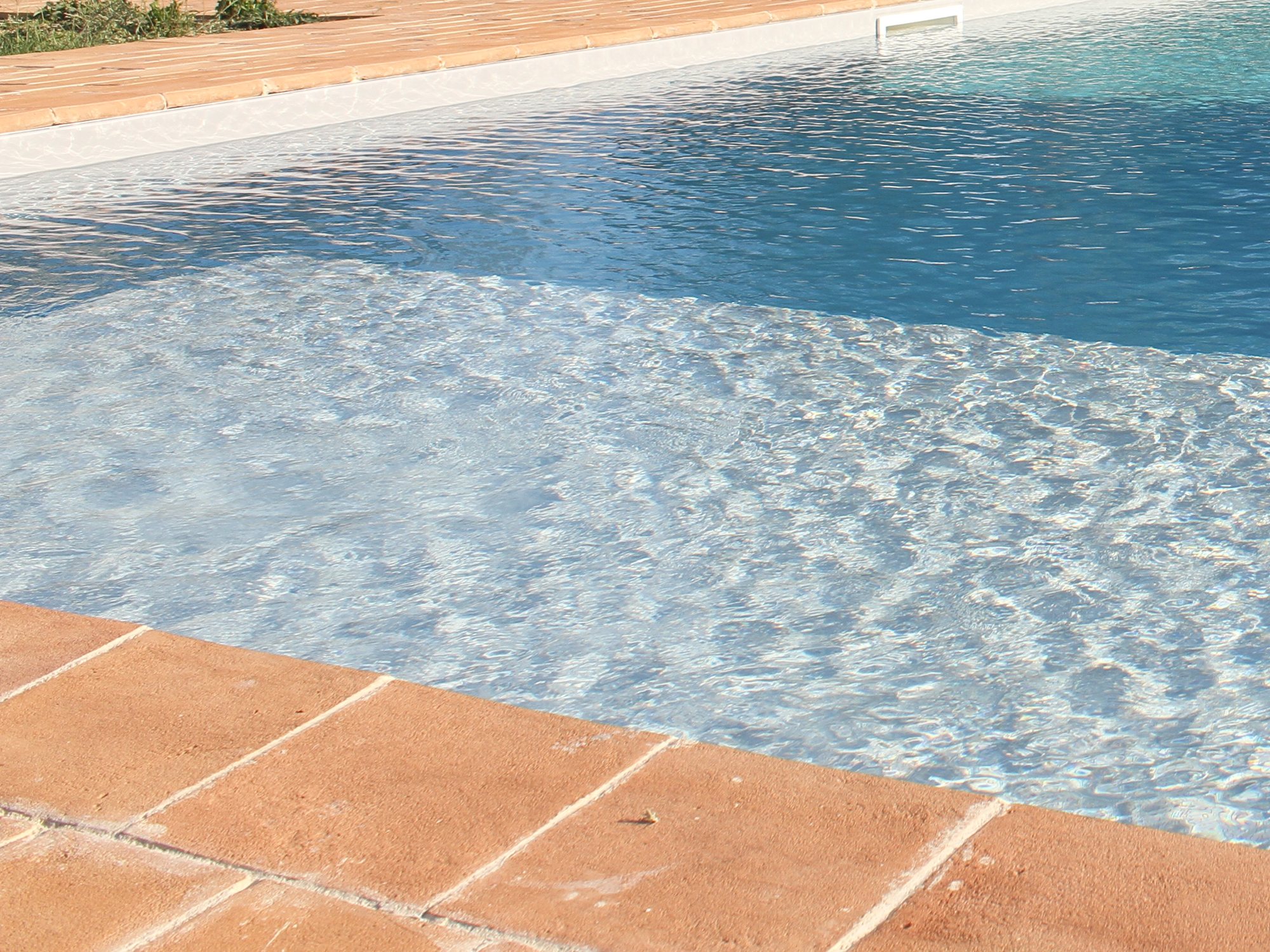 Dettaglio del solarium a bordo piscina