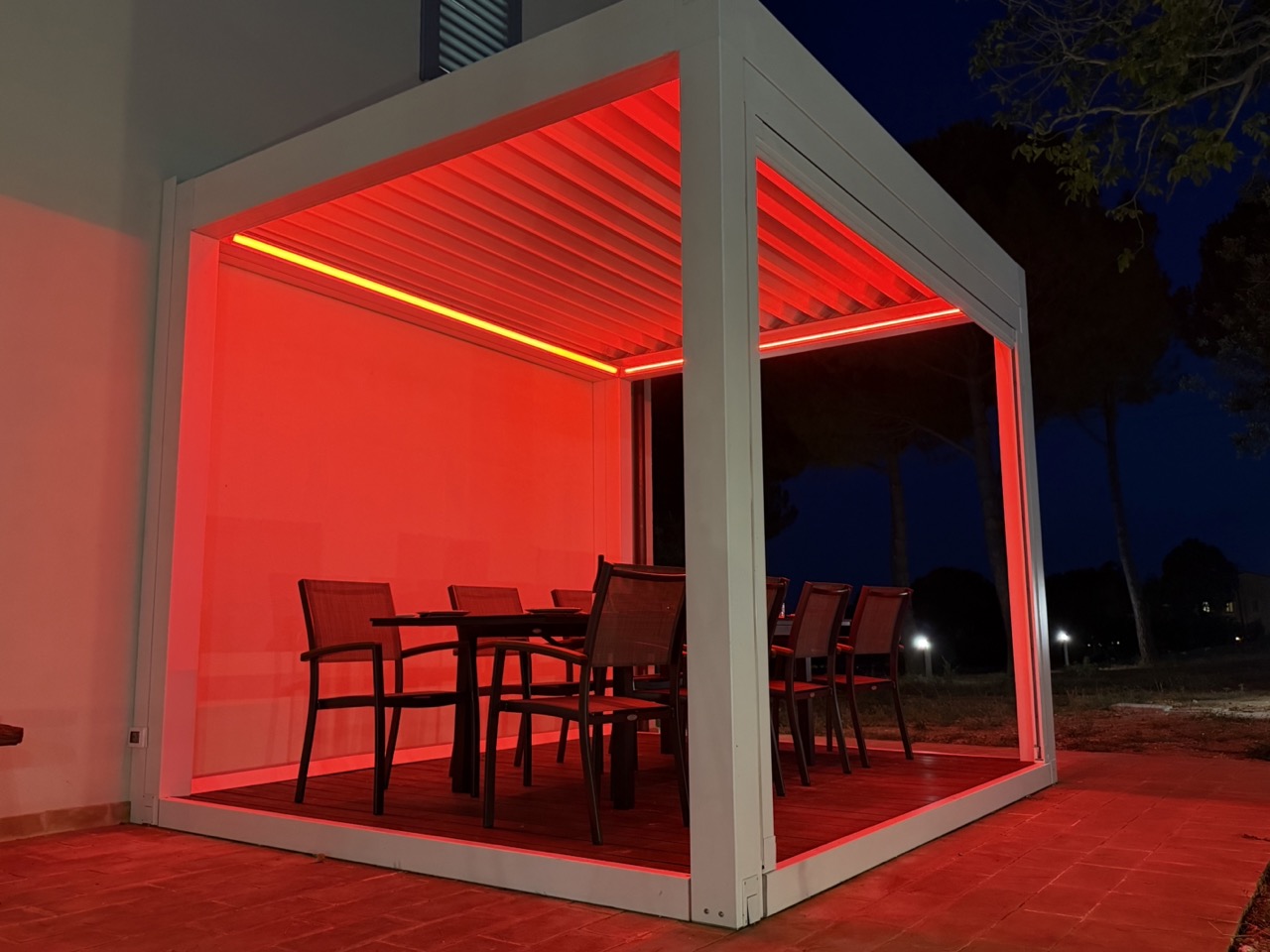 La veranda esterna di The Lodge Perugia illuminata la sera